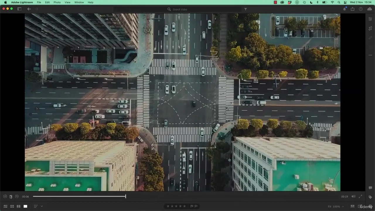 Aerial view of a city intersection with crosswalks, vehicles, and buildings displayed within the Adobe Lightroom interface